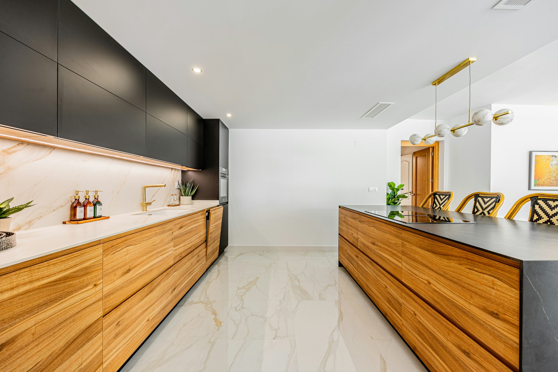Luxury kitchen with dark cabinetry and gold pendant lights